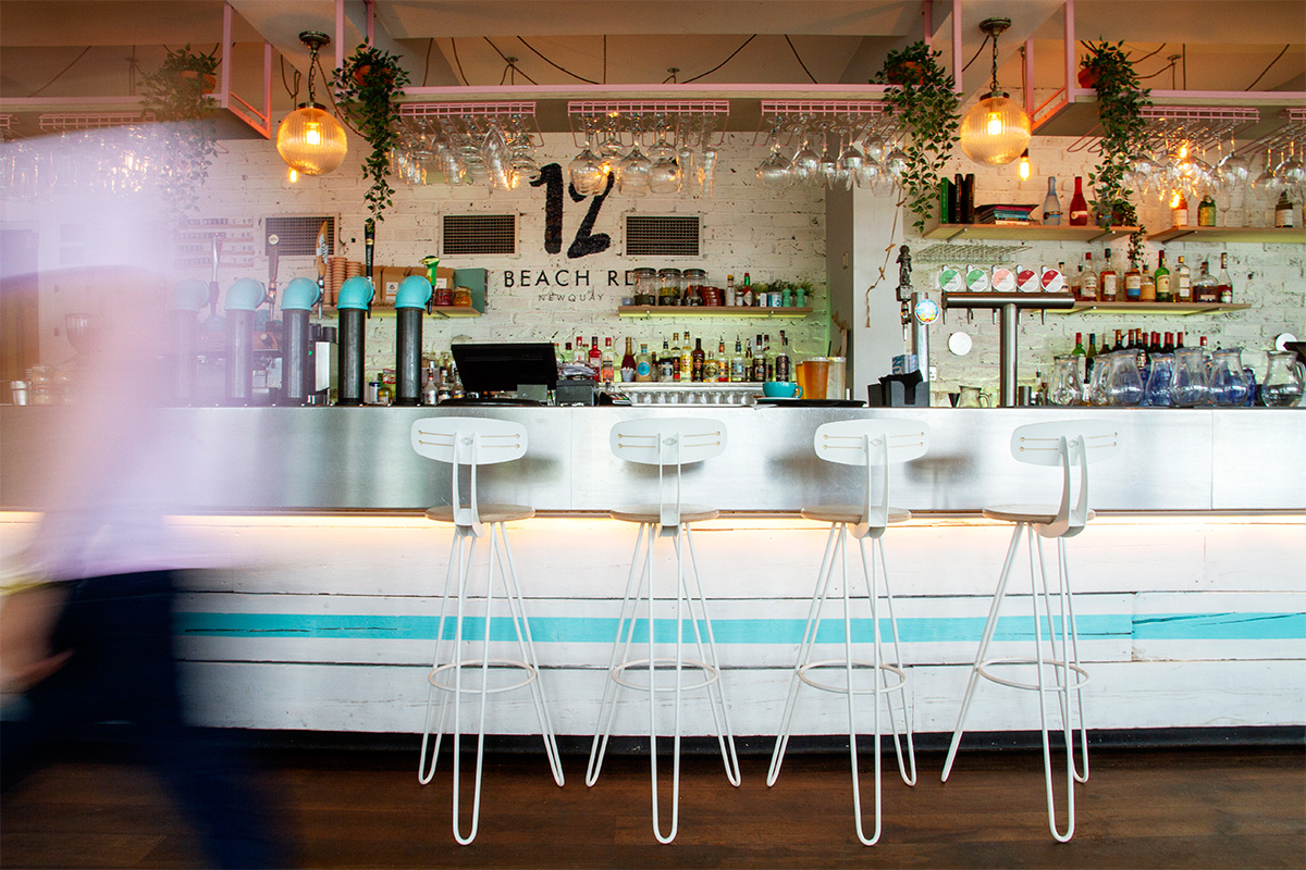 set of four white hairpin leg bar chairs against the bar in at 12 beach road in newquay