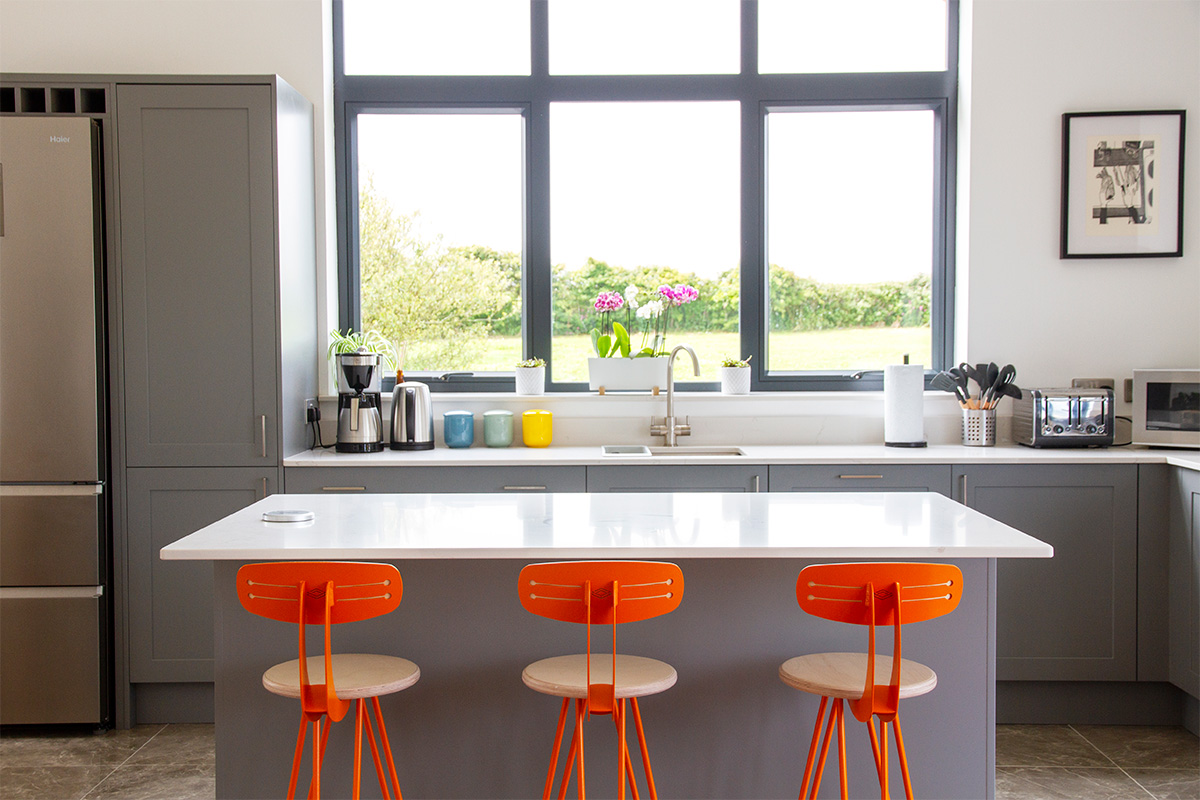 orange bar stools in front of white kitchen island